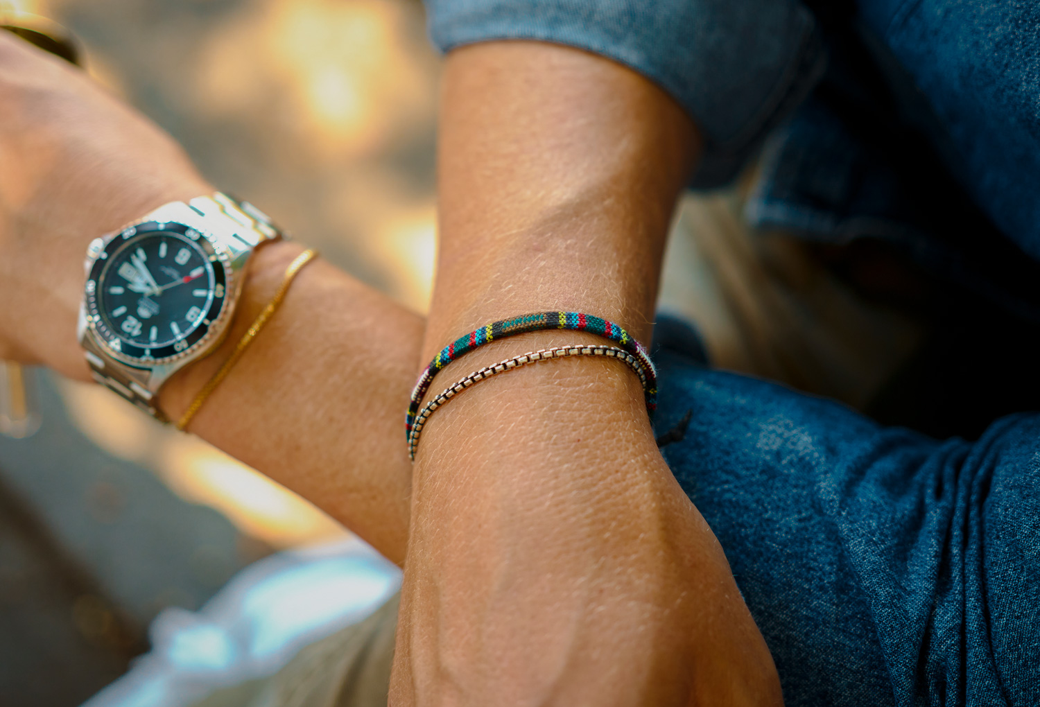 men silver box chain layered with other bracelets and watch