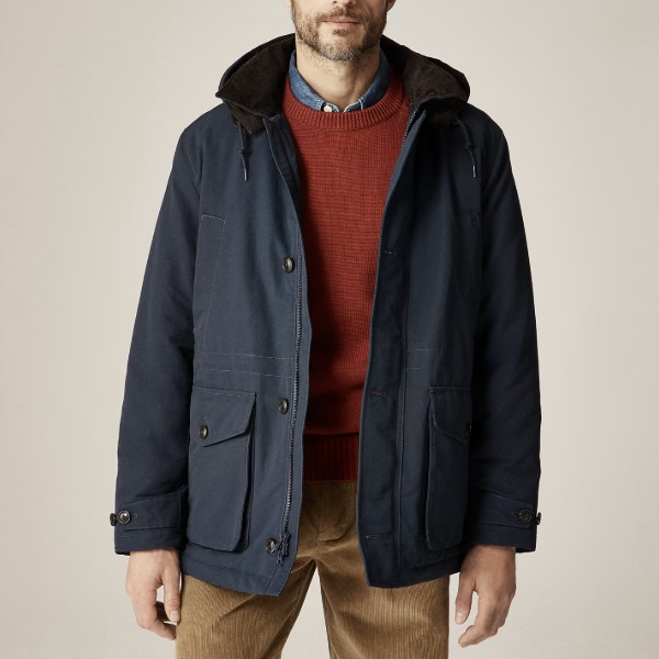 man wearing a hooded jacket over a sweater and pants