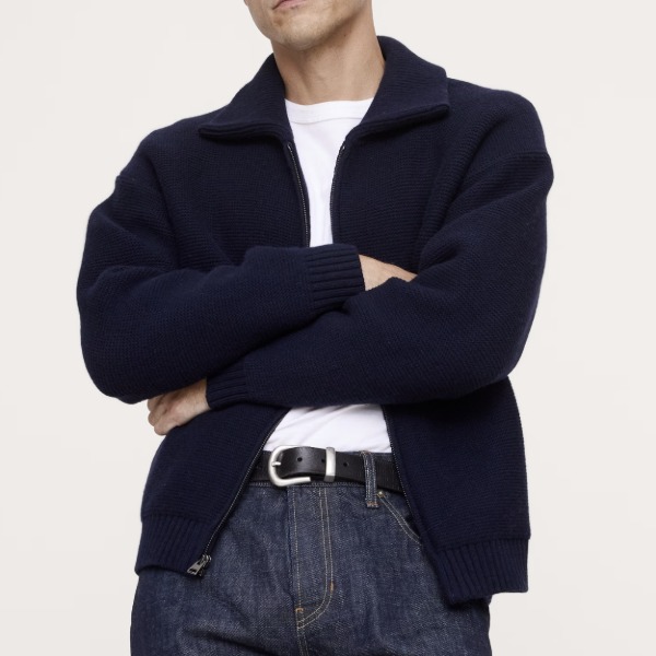 man wearing a ribbed sweater jacket over a shirt and pants