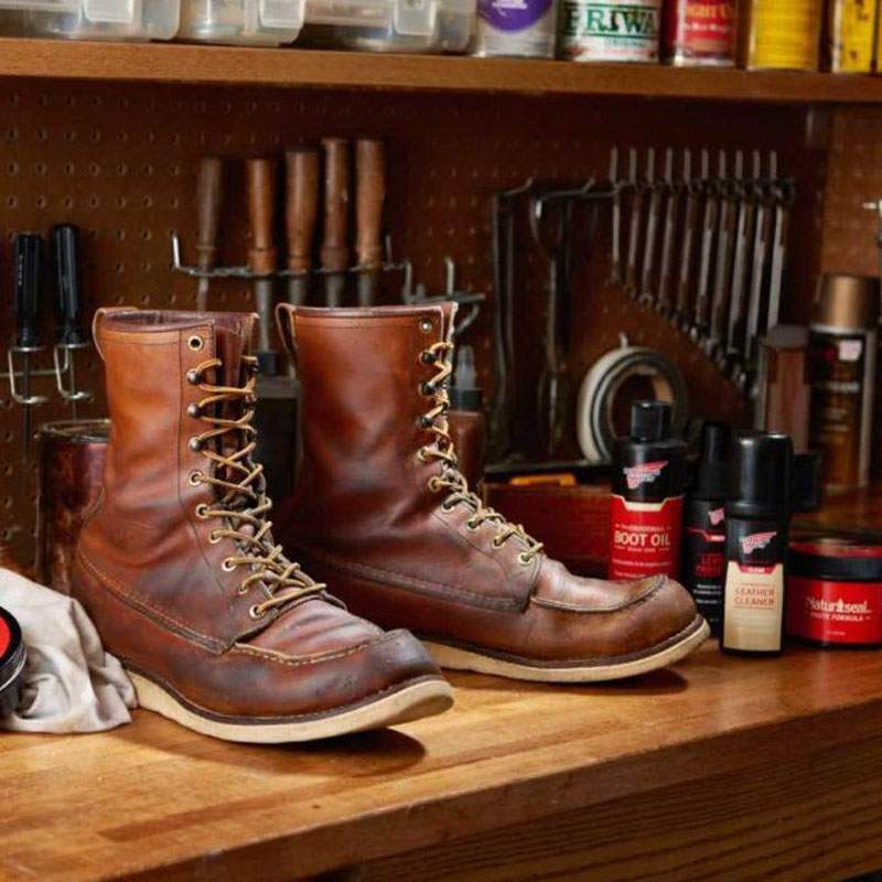 a pair of Red Wing boots on a wooden shelf and ready for repair work