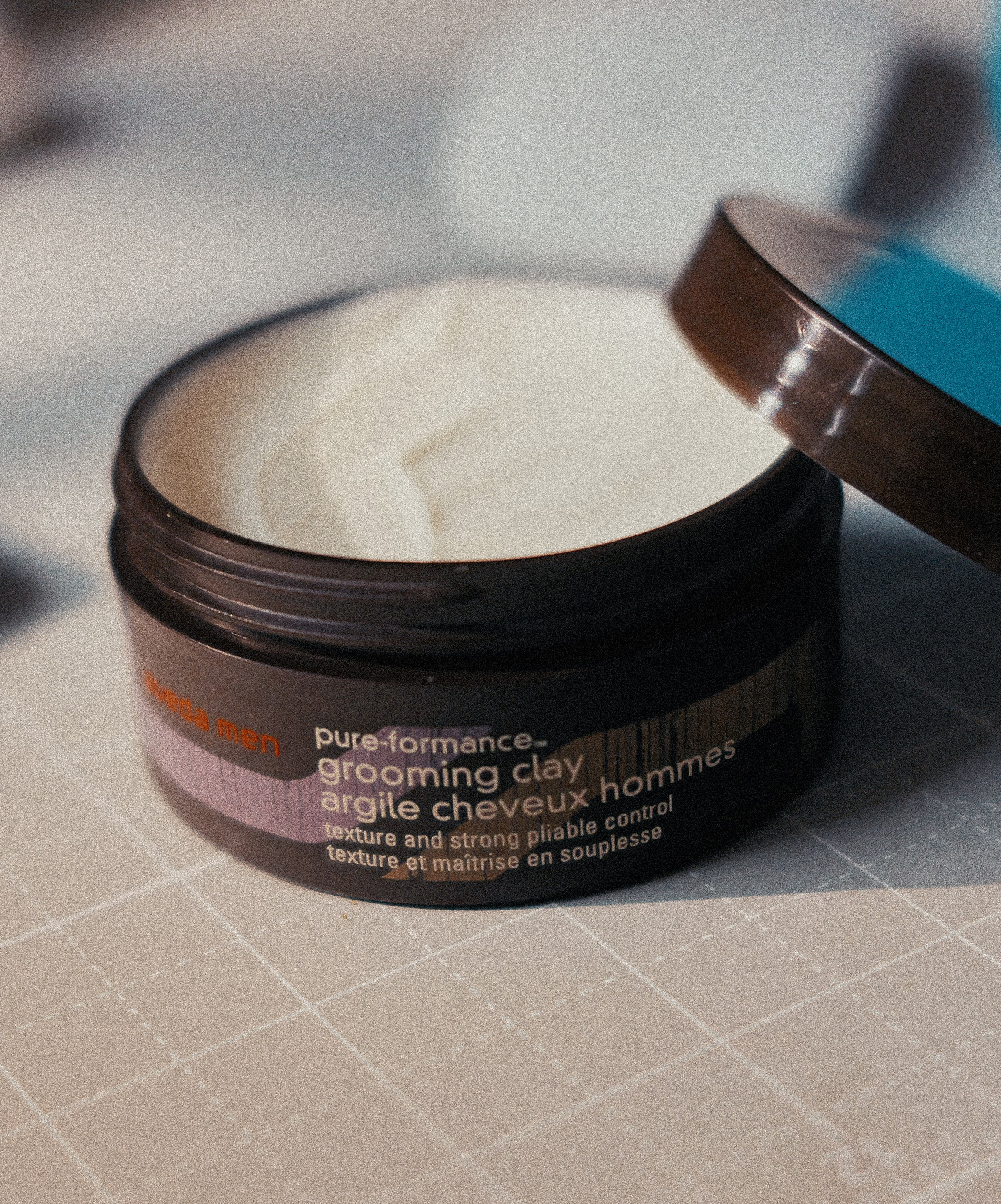 Aveda Men Pure-Formance grooming clay in an open tub