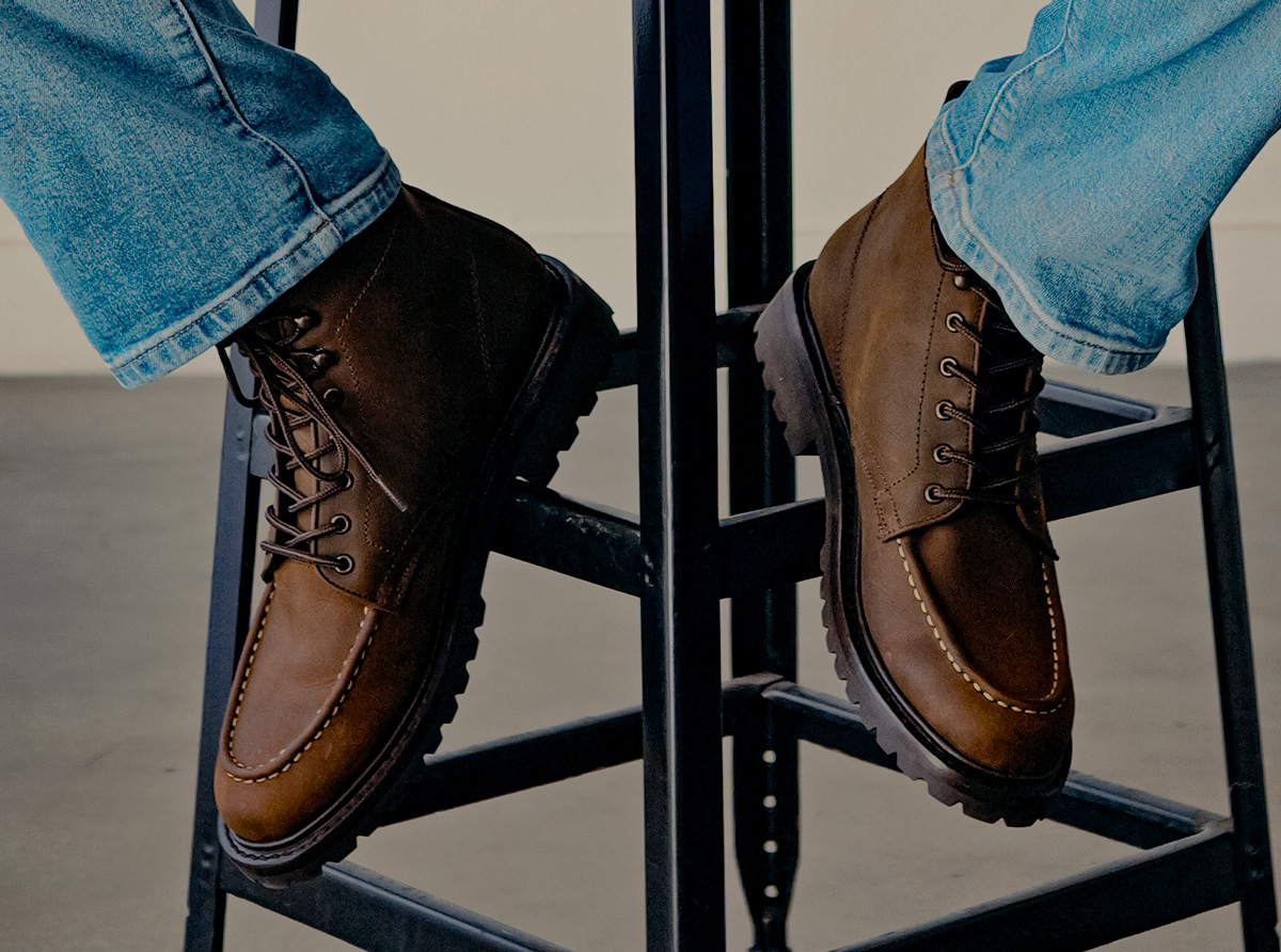 Thursday Diplomat moc toe boots in Tobacco leather worn with light wash jeans, feet up on a stool